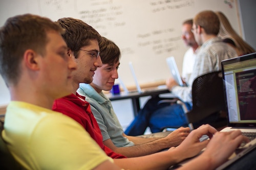 A mentor working with two interns on an iPhone app