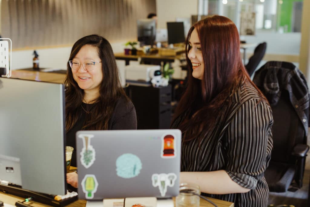 Pictured is author Jing Fan talking to a co-worker. Post title: 3 Tips to Get More Out of Postman