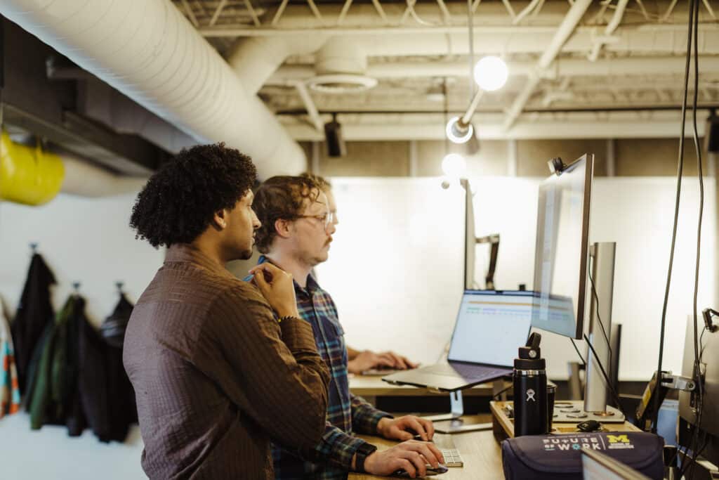 Pictured is author Jacob Williams looking at a monitor. Post title: What I Love About My Warp Terminal
