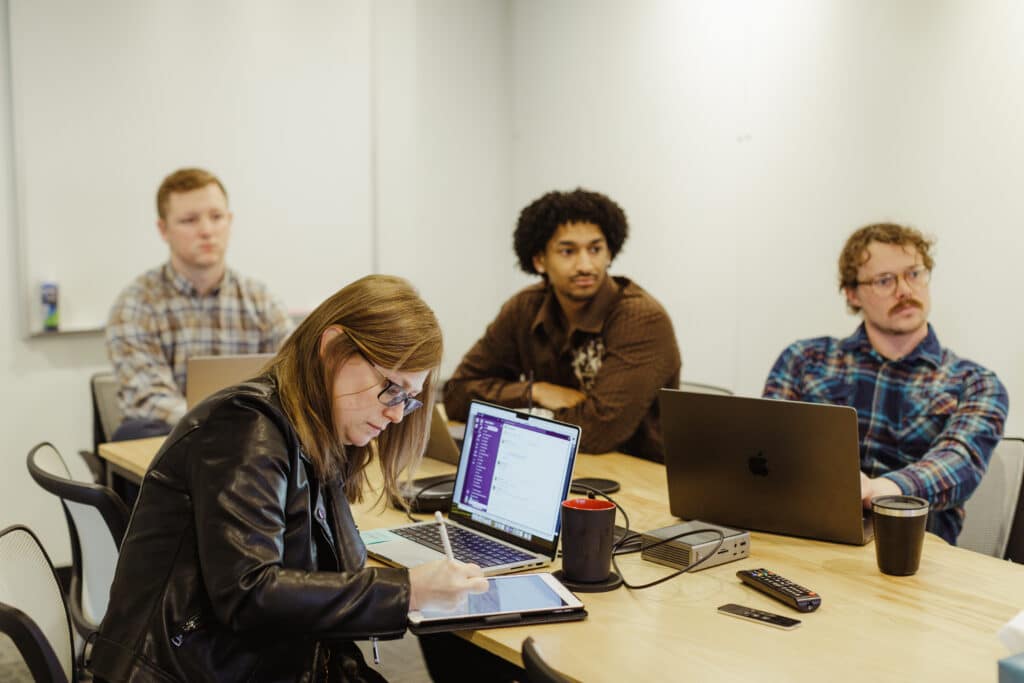 Pictured is author Jared Surato with colleagues. Post title: Here's What I’ve Learned After a Year of Full Time React Native Development