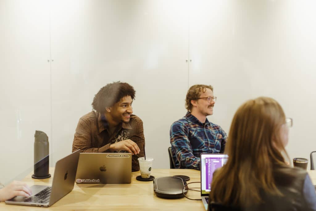 Author Jacob Williams laughing with coworkers. Post title: The Importance of Play & Whimsy at Work