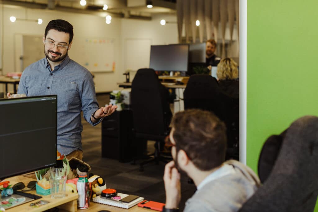 Author Sam Laidlaw chats with a co-worker. Post title: Know Your Audience and Cut the Noise: Executive Storytelling That Actually Works