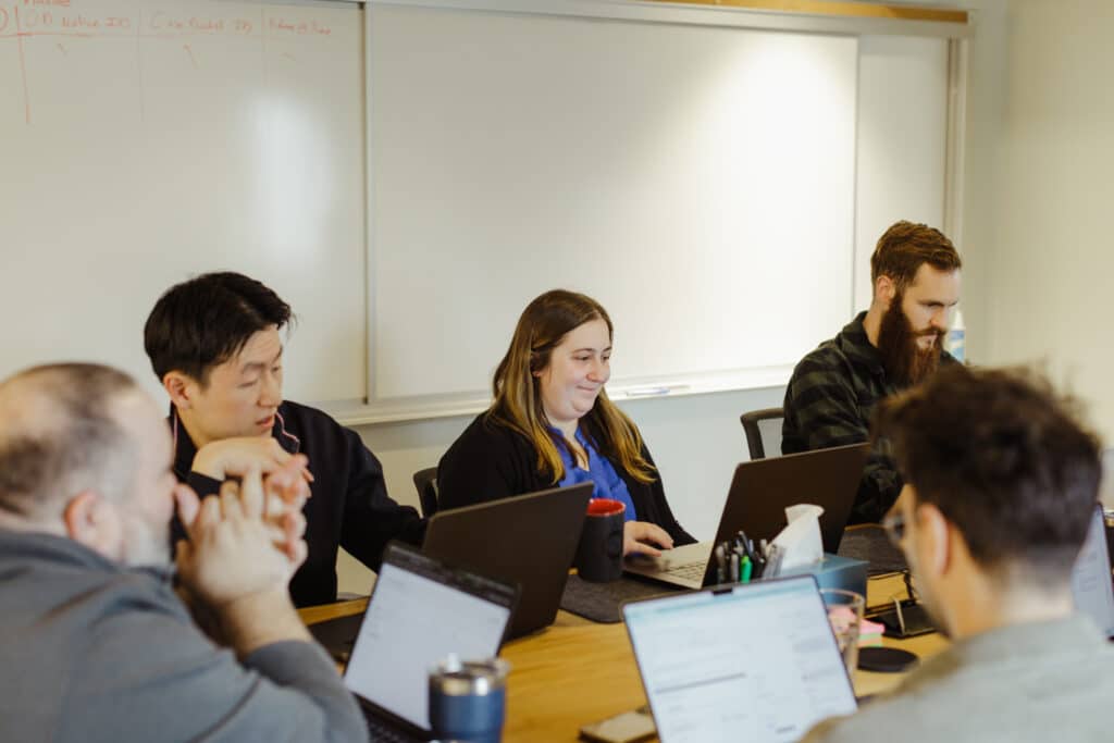 Pictured is author Gus Schissler with teammates. Post title: Building Products for Enterprise Clients: Turn Friction into Collaboration