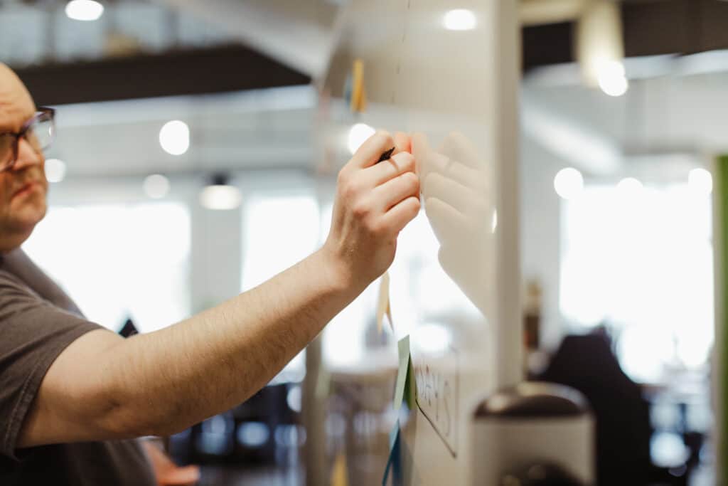 Pictured is author Mattie Behrens writing on a white board. Post title: Your software isn't something you can be done with