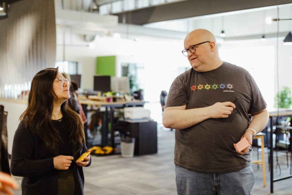 Author Mattie Behrens (R) talks with a co-worker about this post: A Webserver and a Slack Bot on OpenBSD: Introducing relayd