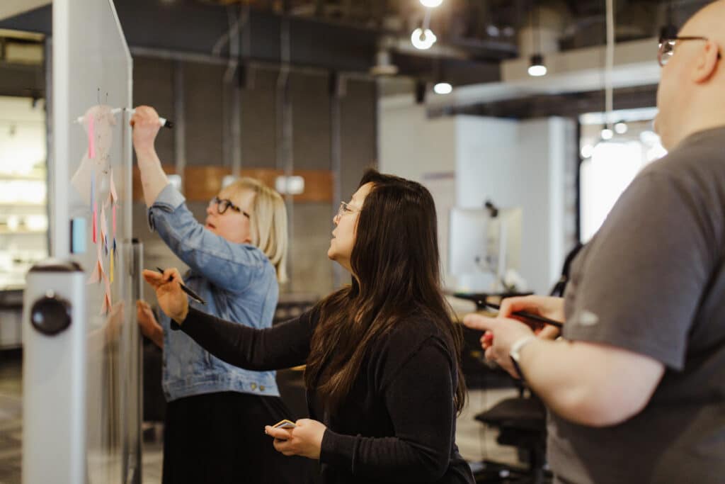 Pictured is author Jing Fan writing on a whiteboard. Post title: How and When to Use Feature Flags in NextJS