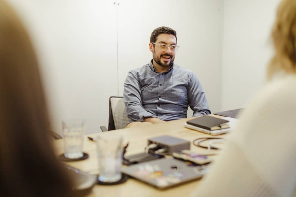 Pictured is author MIke Ficocelli talking to co-workers. Post title: The Art of the Nerd Snipe: Ask Questions People Want to Answer