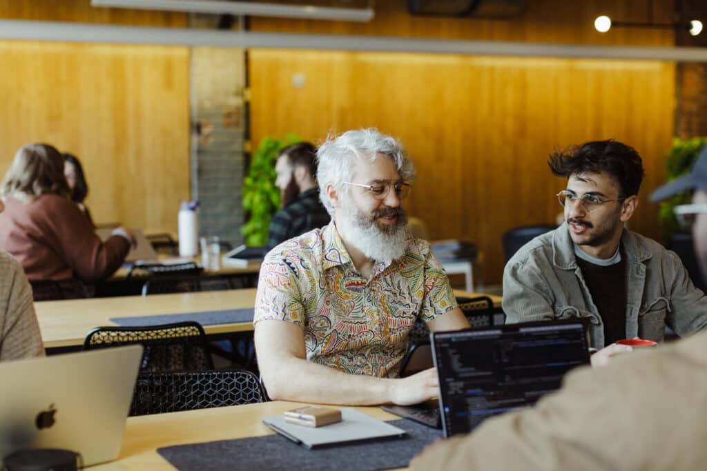Pictured is author Dylan Goings with co-workers. Post title: An AI-Powered Development Workflow for Solo Builders
