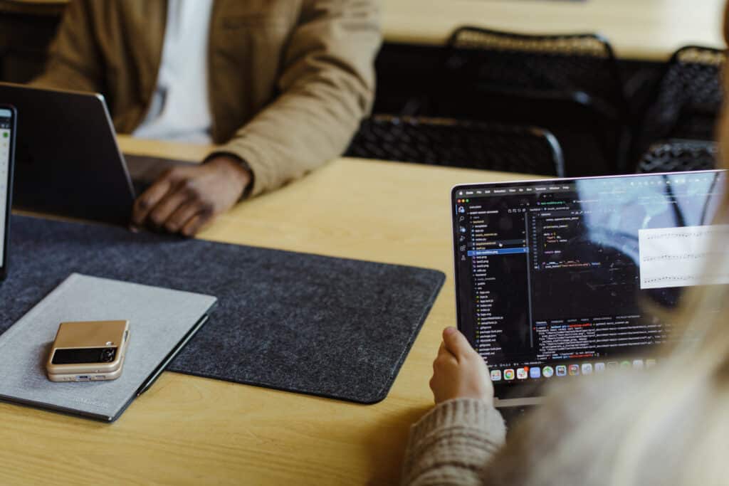Pictured are hands on a laptop. Post title: How Coding with QA in Mind Has Made Me a Better Developer