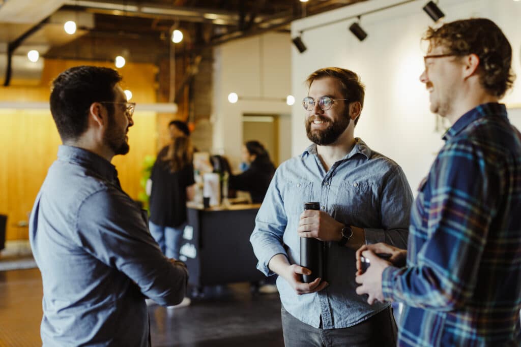 Author Patrick Pale is shown chatting with colleagues about his latest Spin post, "An Overview of 8 Years of Projects as a Software Consultant"