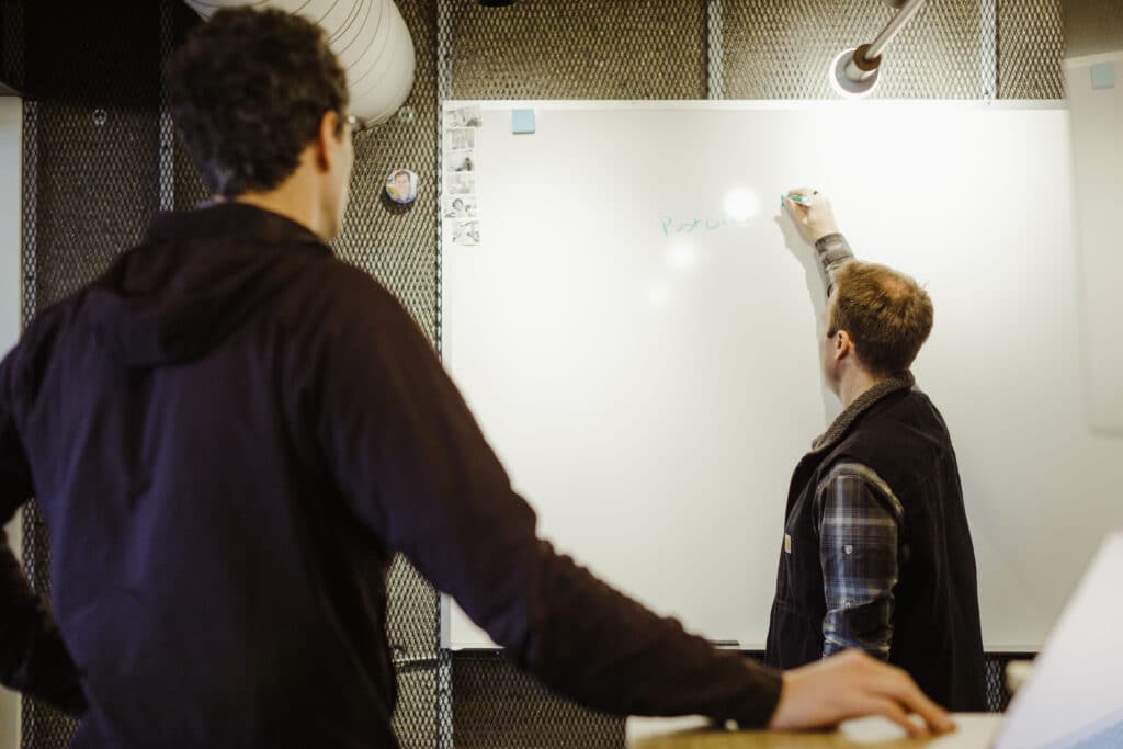 Shown are two co-workers looking at a whiteboard together. Post title: What I Learned from a Quarter of Intentional Growth