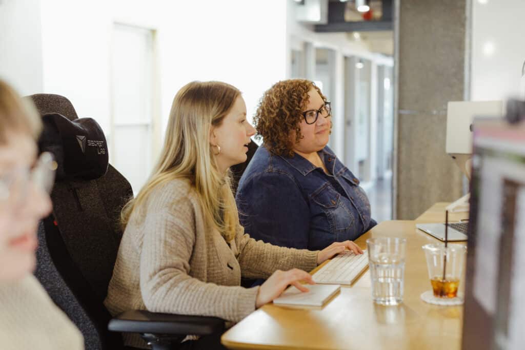 Two developers looking at a monitor together. Post title: 5 Tips to Accelerate Your Growth as a Junior Developer