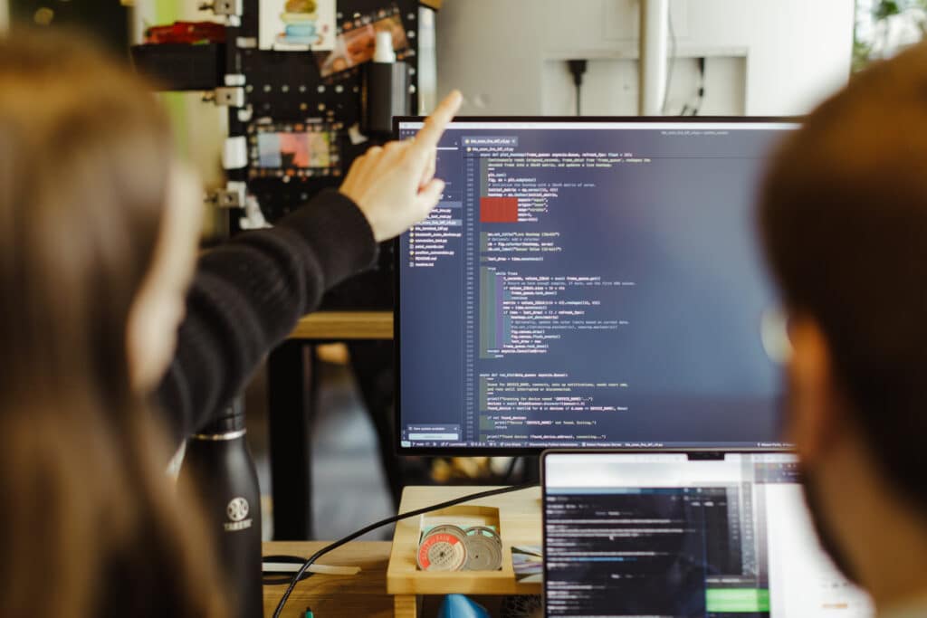 Pictured are two developers looking at a monitor. Post title: The Junior Dev's Intro to Vimrc
