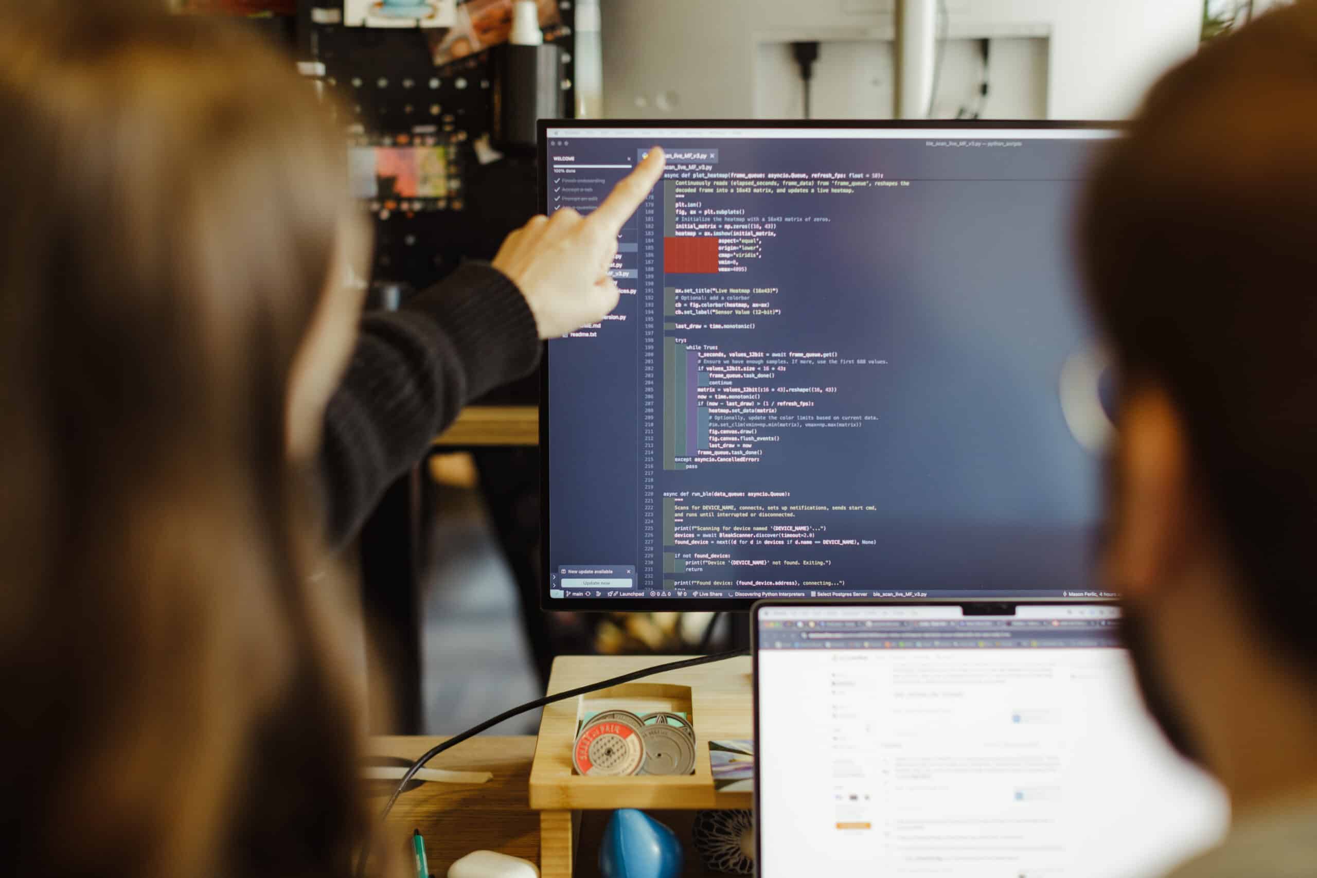 Pictured is a person pointing at a computer monitor filled with code. Post title: Stakeholder Communication Strategies for Successful Projects