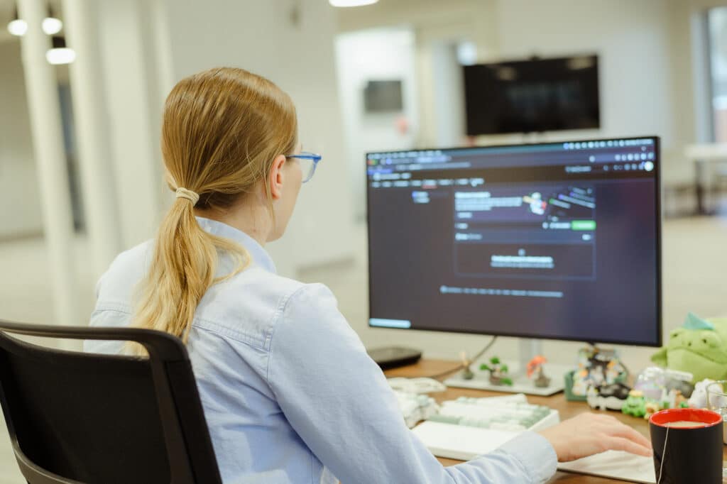 A developer looks at her monitor. Post title: Don't AI Everything: Deterministic vs. Variable Outcomes in My Claude Skill