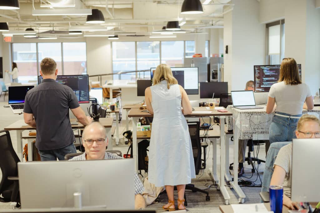 Developers at their workstations in the Raleigh office of Atomic Object. Post title: Atomic Object on AI: MCP Servers