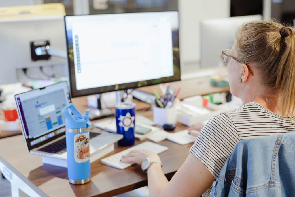 A developer codes at her desk. Post title: AI This, Optimise That – But What Does Coding With It Actually Look Like?