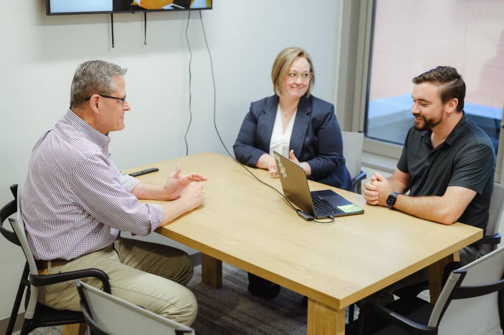 Author Chris Johnson chats with co-workers. Post title: Living Atomic’s Values as a New Delivery Lead