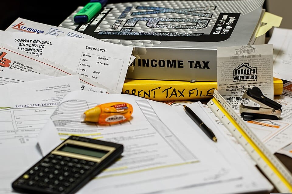 Pictured: A pile of paperwork with the words INCOME TAX clearly visible. Post title: Why Programmers Should Do Their Own Taxes