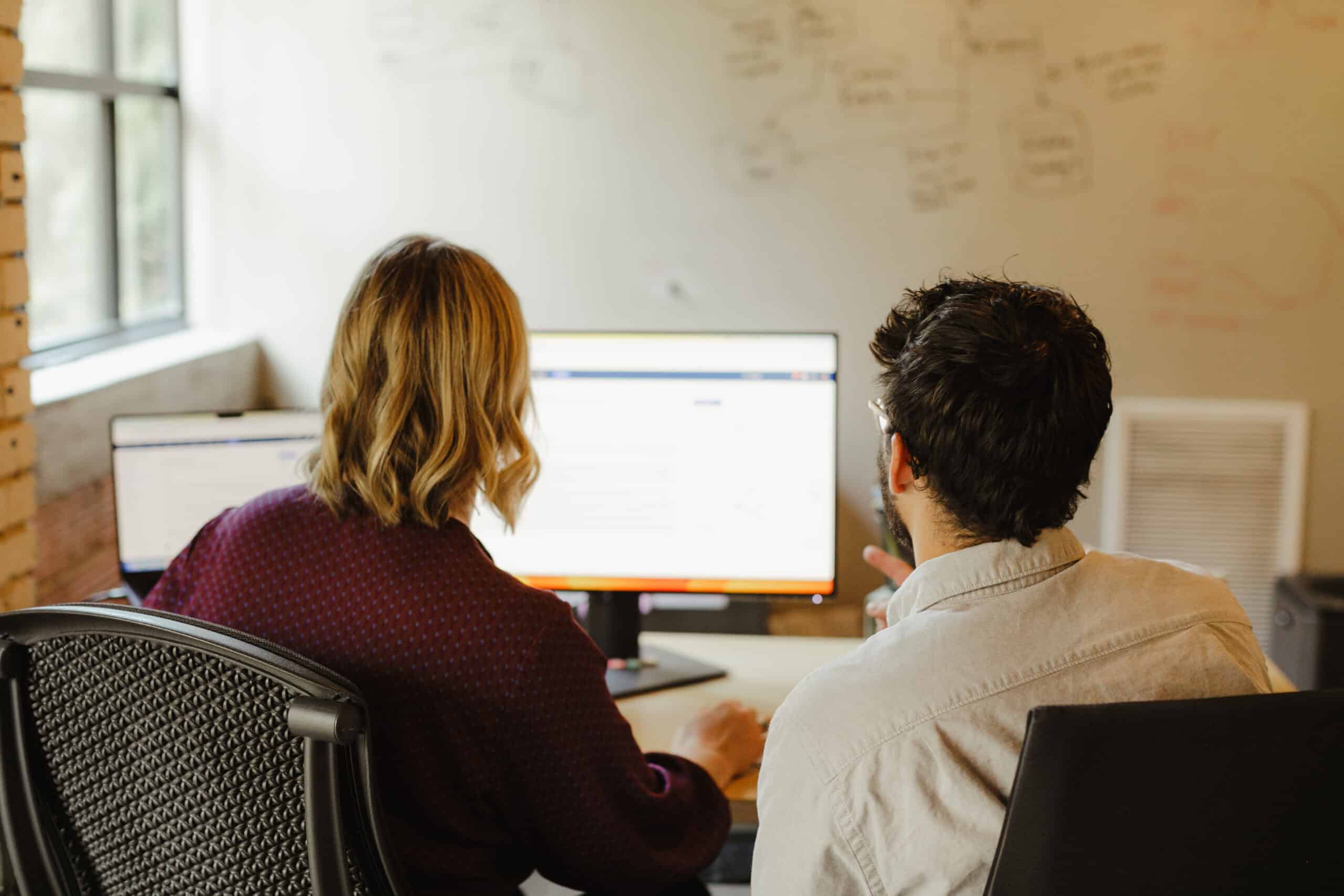 Pictured are two developers looking at a monitor. Post title: Switching Industries: How to Thrive Through Career Change