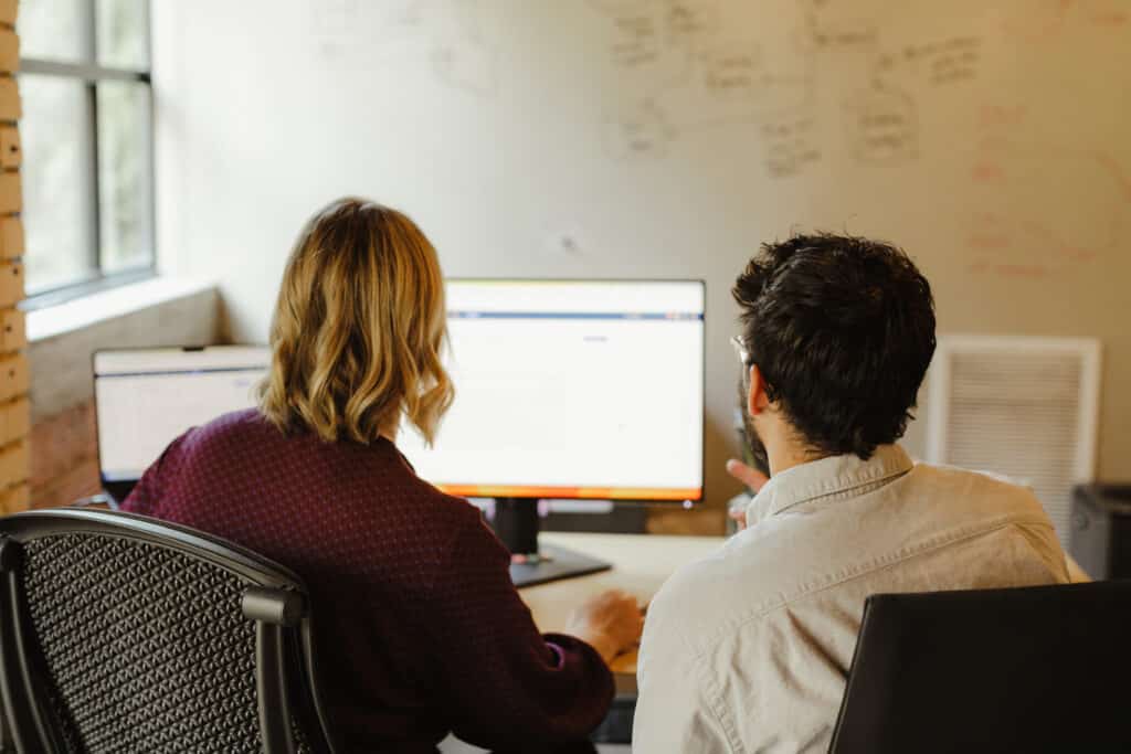 Pictured are two developers looking at a monitor. Post title: Prevent Lost Updates in EF Core: Optimistic vs. Pessimistic Concurrency