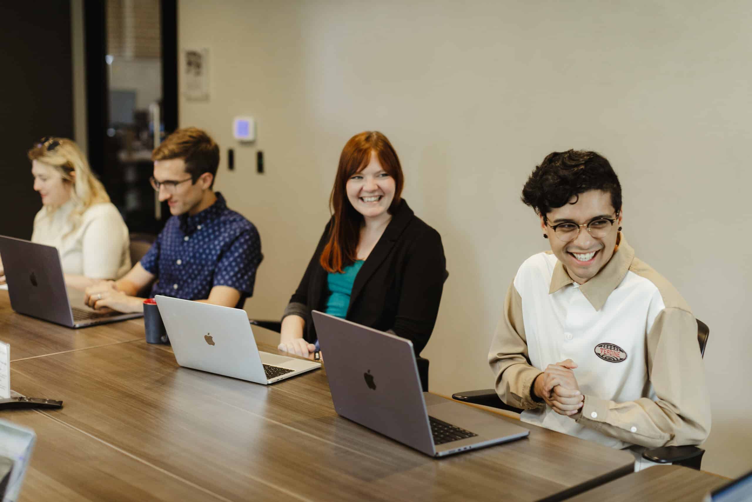 Pictured is author Kendra Haan laughing with co-workers. Post title: Stay Engaged with Your Software Project Even When the Sun’s Out