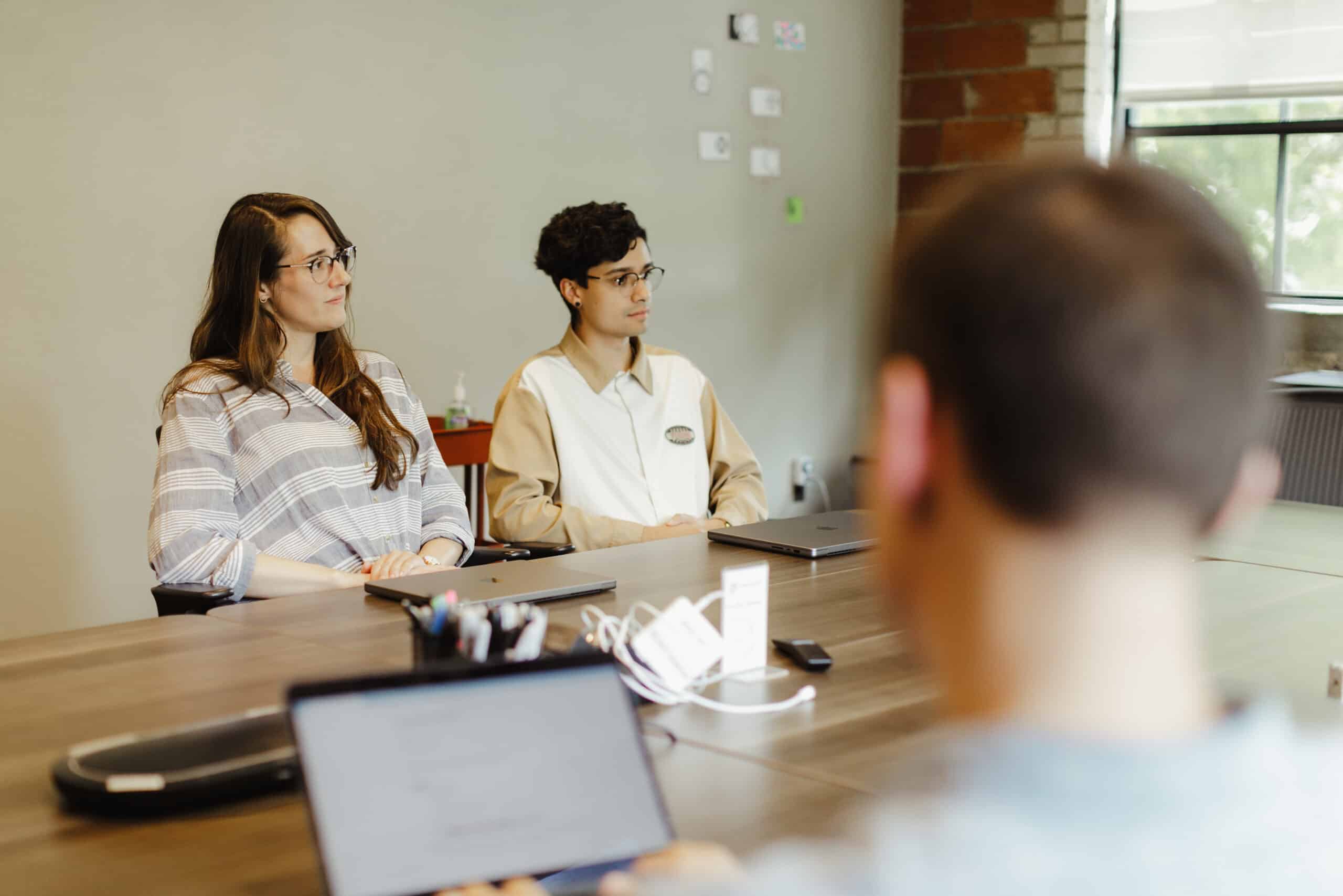 Pictured is author Meghan Harris talking to co-workers about software development environments with no tests.