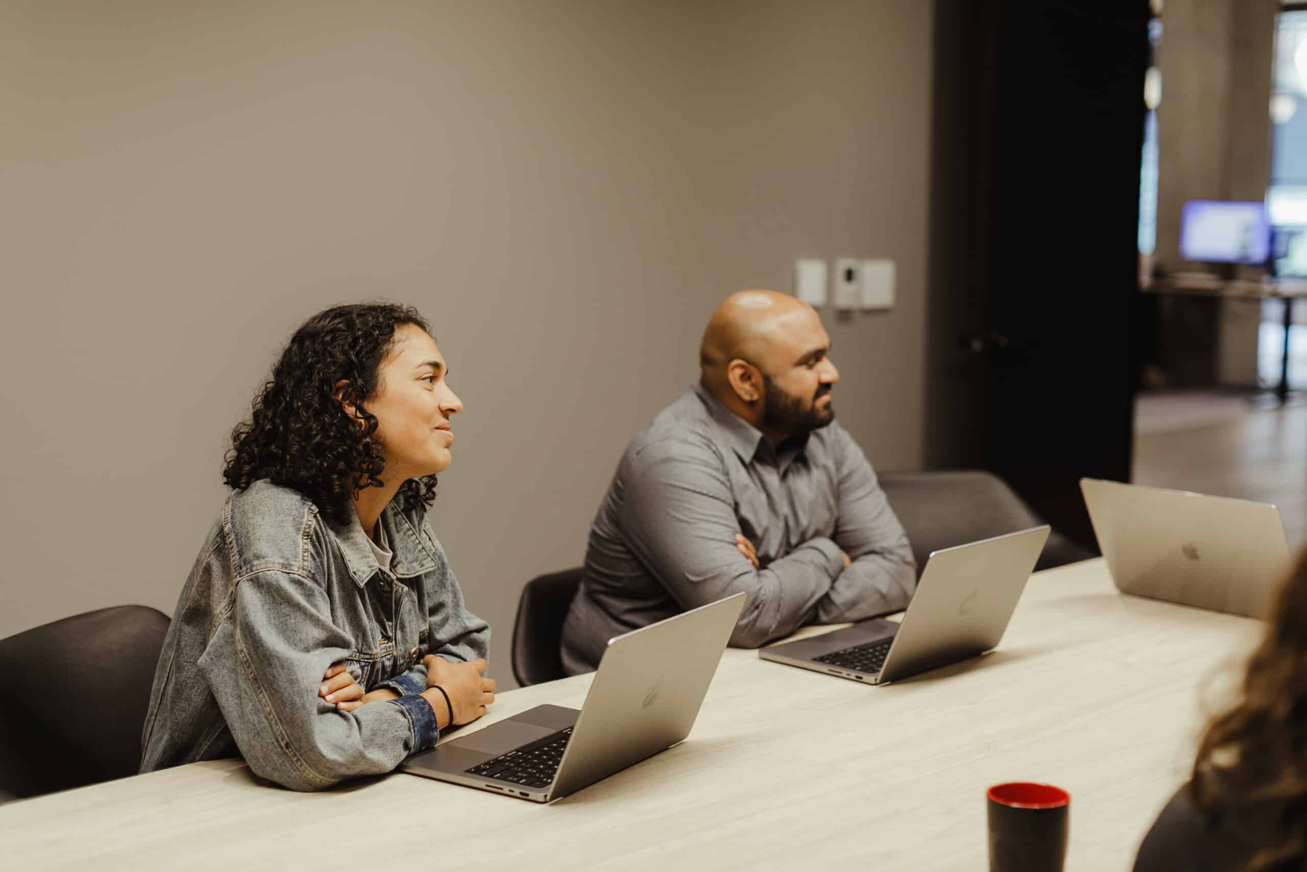 Pictured are two developers with laptops discussing using Zod to Upgrade Your Form Validation