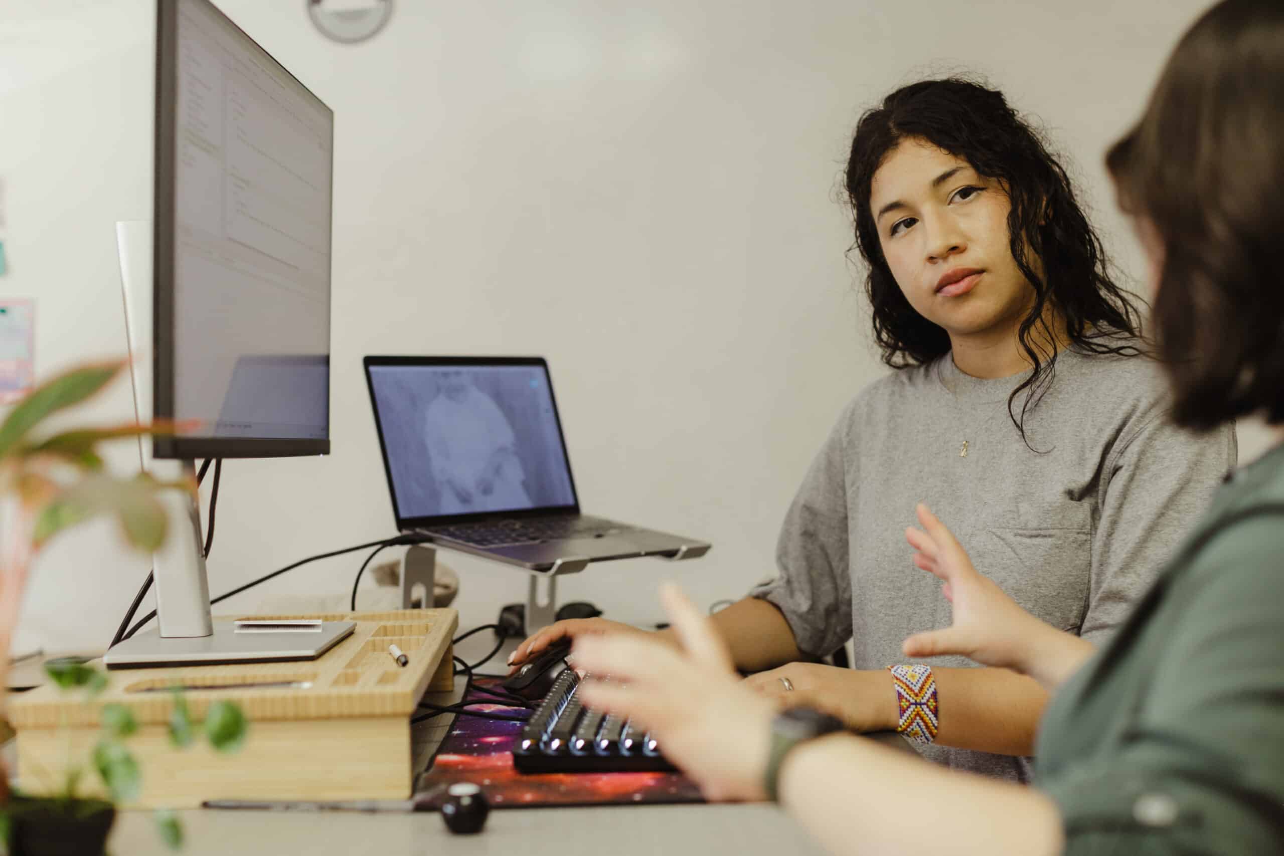 Pictured is author Viviana Rosas talking with a co-worker. Post title: Git Good: Aliases with Spice