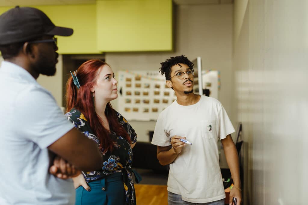 Pictured is author Doug Shipp with colleagues. Post title: Streamline Your Code Reviews: How AI-Powered PR Summaries Save Time and Improve Team Collaboration