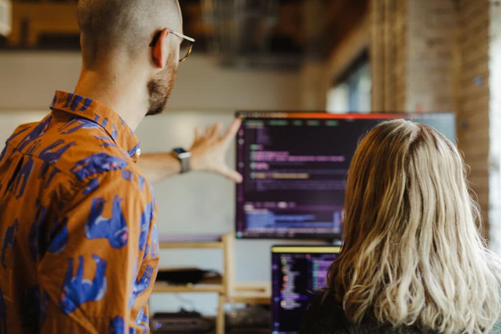 Shown are a designer and developer looking at a monitor together. Post title: AI Can't Read Your Mind: My Attempt to Build a WebApp with chatPRD + v0