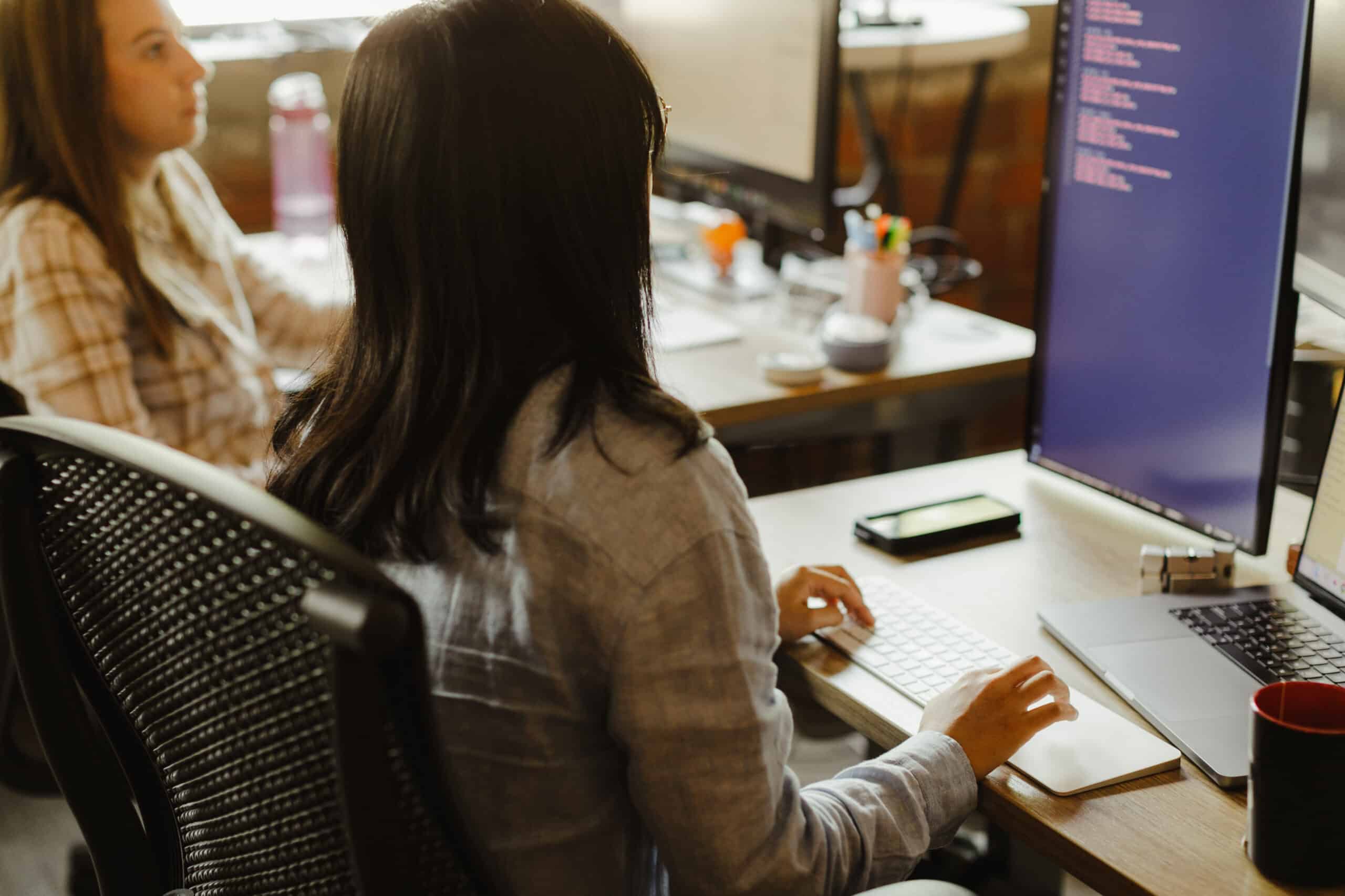 Pictured is author Lydia Cho looking at a computer screen with a co-worker. Post title: Managing the State of Your Promises