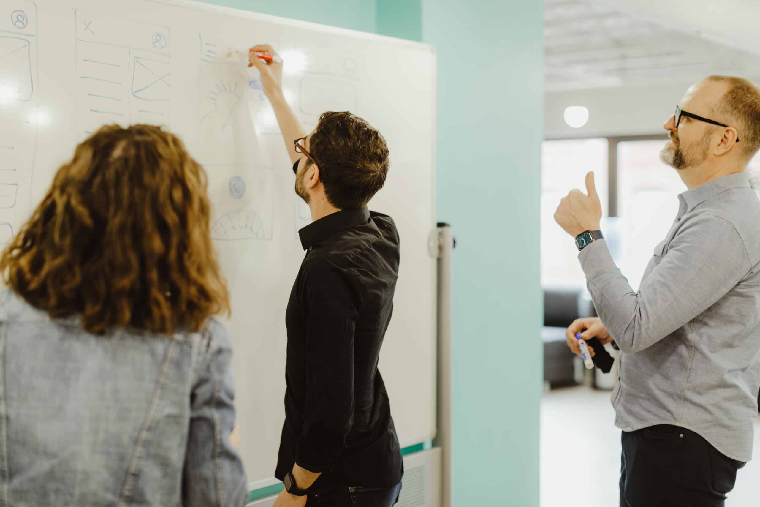 Pictured is author Matt Soto writing on a whiteboard. Post title: What's the "points" of agile, anyway?