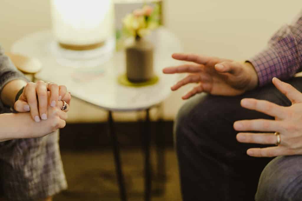 A closeup of the hands of two people having an intense conversation. Post title: Moving from Autopilot to Aware: Mindfulness as a Tool for Combating Friction in Communication