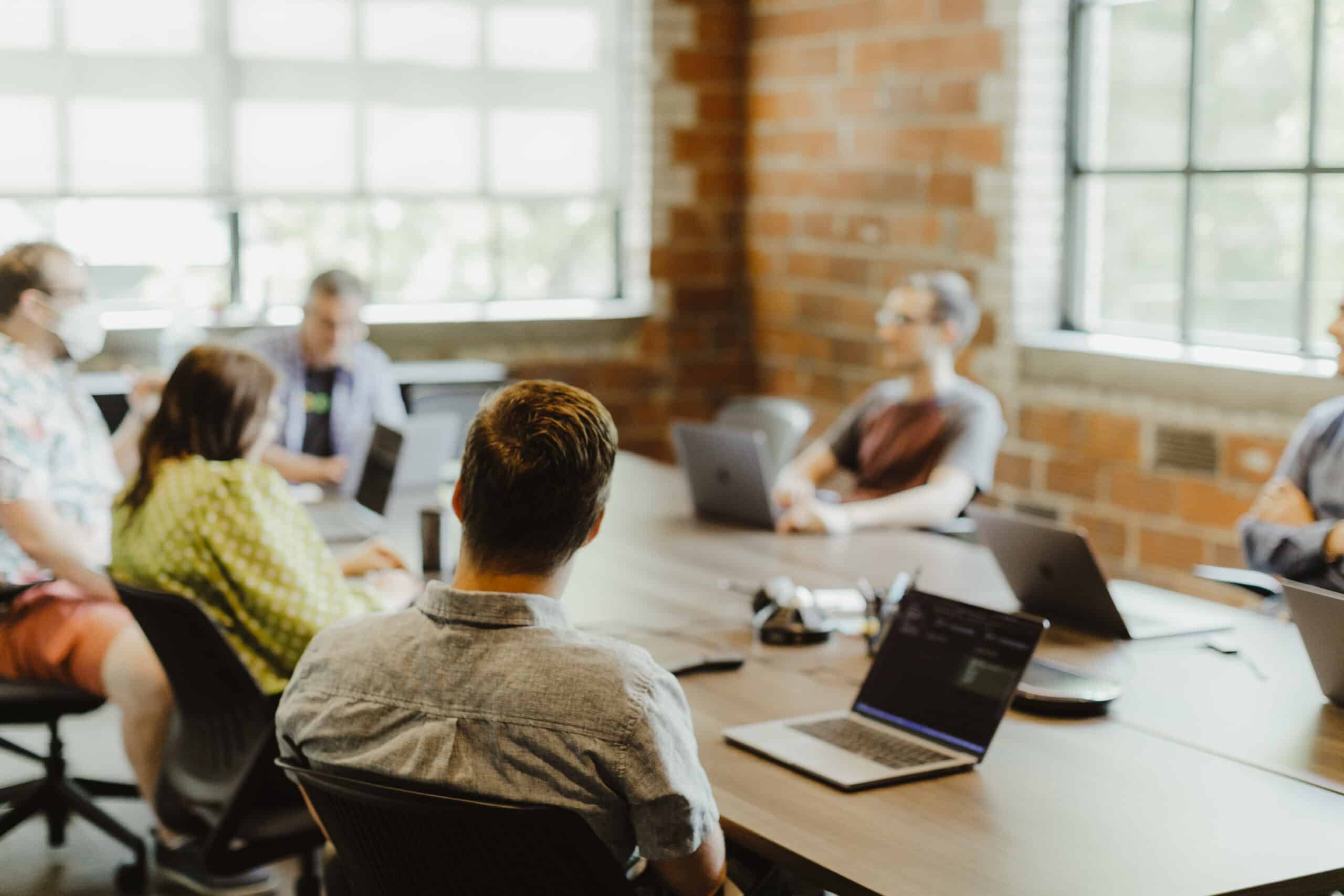 Pictured is a group of developers sitting around a table. Post title: Why I Still Time‑Box Every Story I Touch