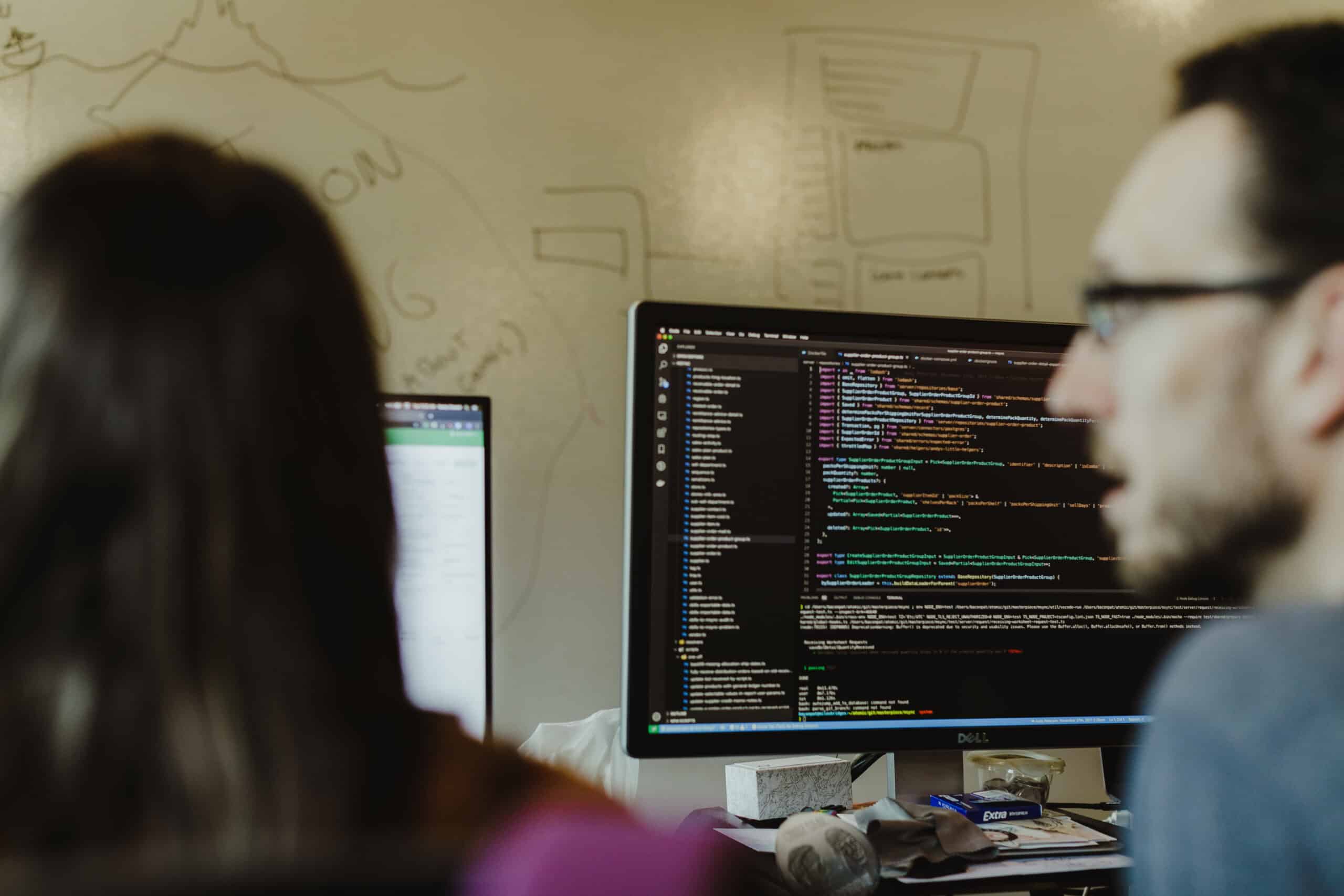 Pictured is author Patrick Bacon looking at a monitor. Post title: The Entity Framework WHERE IN vs OPENJSON Problem
