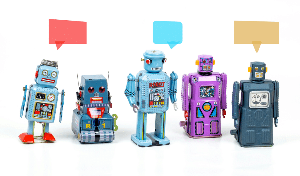 A row of different colored robots, a few with chat bubbles above their heads: Synthetic User Research is a Terrible Idea