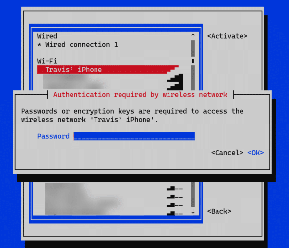 Screenshot of a NetworkManager TUI interface showing a Wi-Fi selection menu. "Travis’ iPhone" is highlighted under the Wi-Fi section. A pop-up dialog displays the message "Authentication required by wireless network", asking for a password to connect to the wireless network 'Travis’ iPhone'. A blue password input field is shown, along with "<Cancel>" and "<OK>" options.