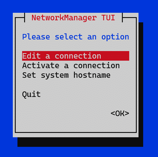 Screenshot of the NetworkManager TUI (Text User Interface) menu with the title "NetworkManager TUI" in red. The prompt reads "Please select an option" in blue. Menu options include "Edit a connection" (highlighted in red), "Activate a connection", "Set system hostname", and "Quit". An "<OK>" button is shown at the bottom right.