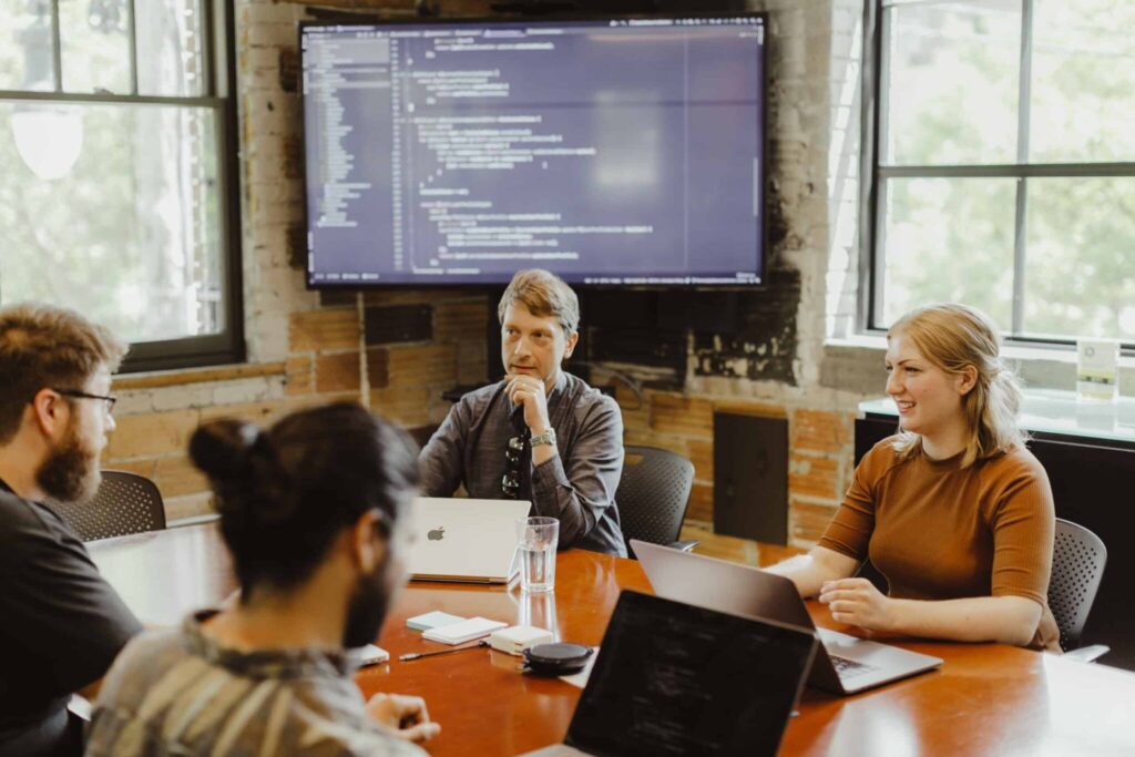 Pictured is author Lauren Ebels talking to her team. Post title: Accelerate Projects With Vibes, Not Regrets