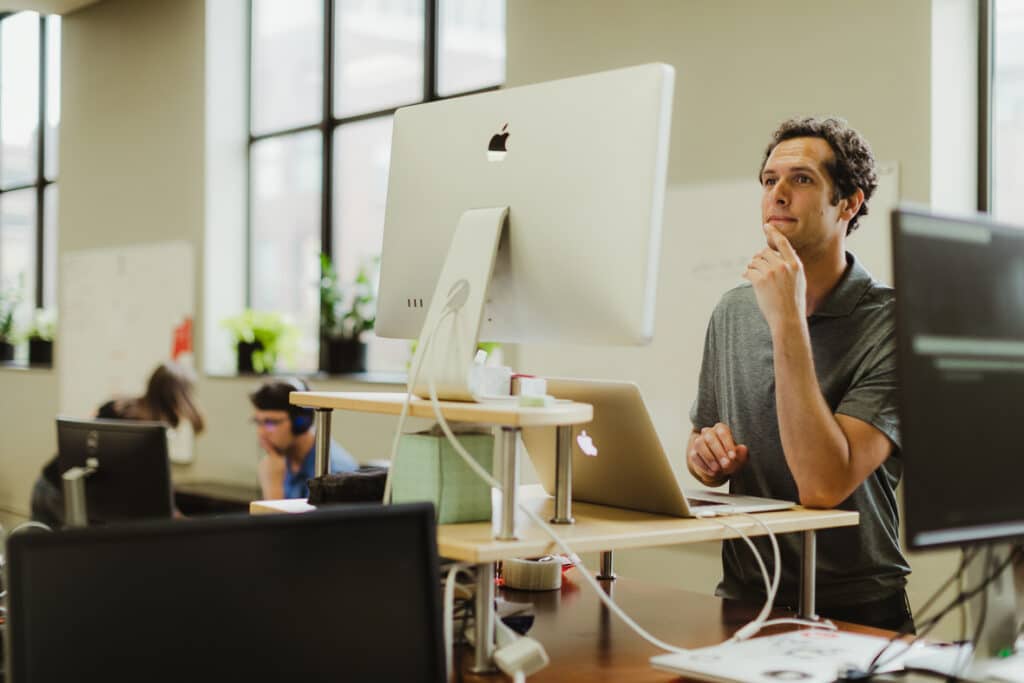 Shown is author Bryan Elkus at his desk, thinking about his post titled "Product Design Is Changing in the World of AI and Agentic Tools"