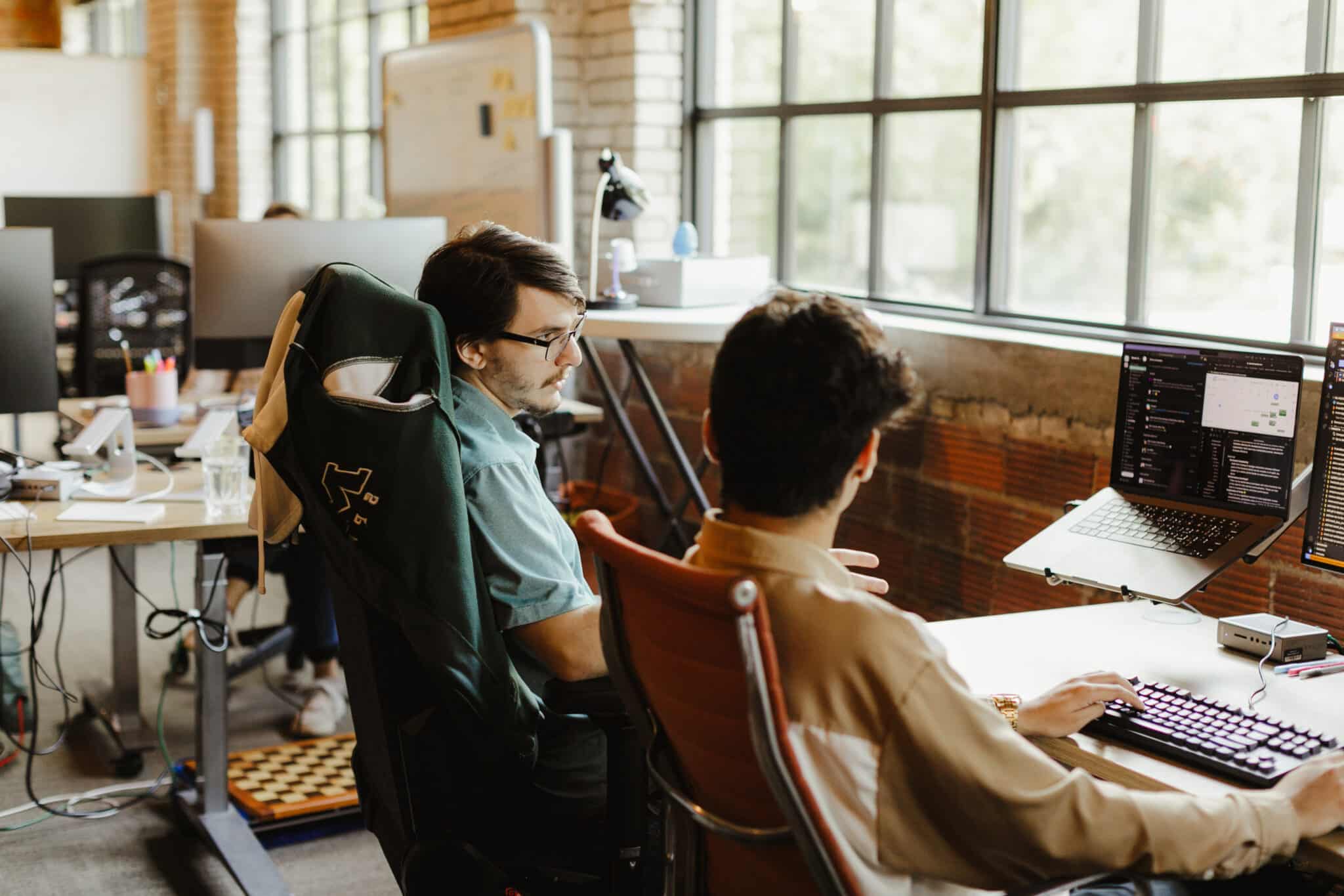 Pictured is author Allen Janyska looking at a monitor and talking to a co-worker. Post title: Switch Statement Guide for C#