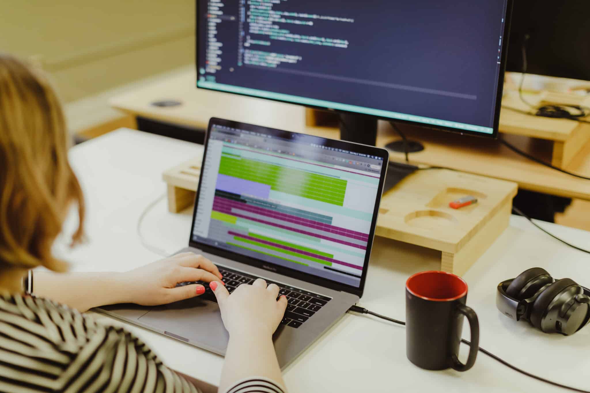 A delivery lead types on her laptop. Post title: Build Alignment Using a Product Requirements Document