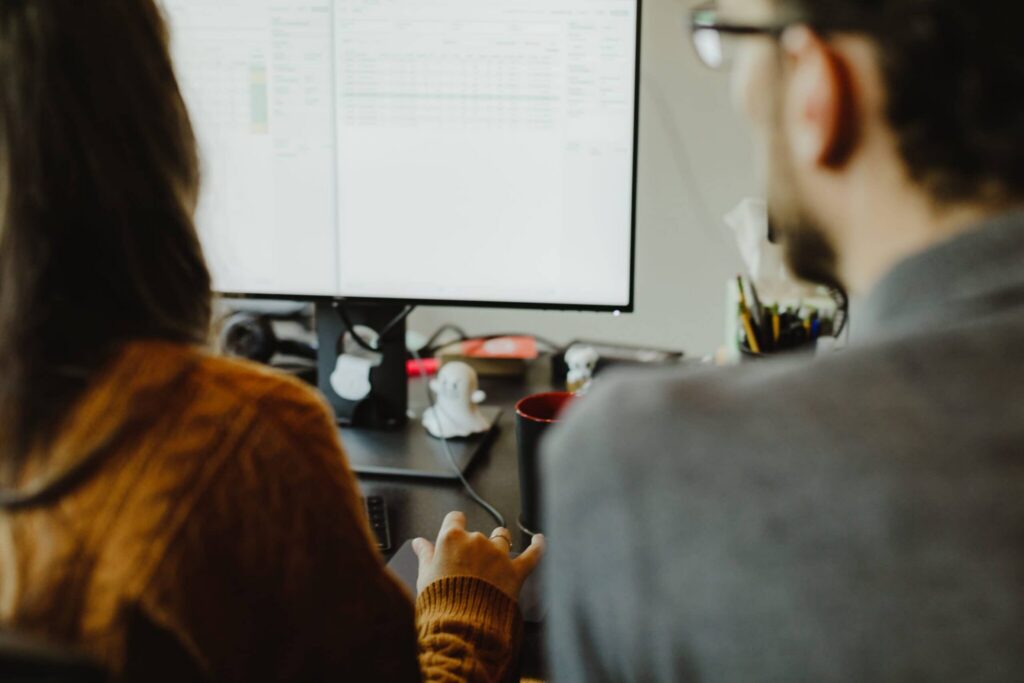 Author Patrick Bacon looks at a monitor with a colleague. Post title: Connect to a VPN-in-a-VM Using WireGuard