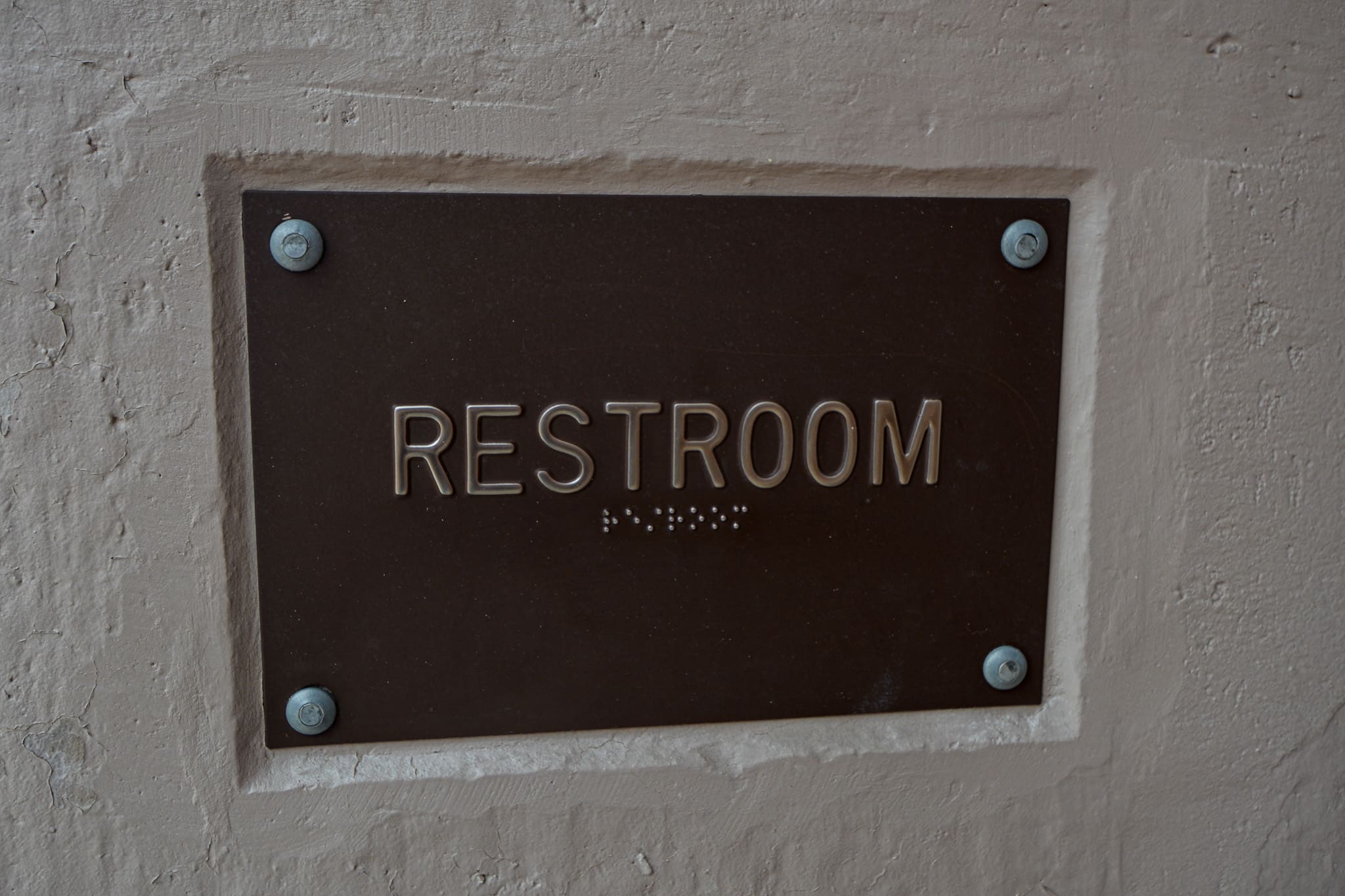 Pictured is a sign saying "Restroom" with Braille under the words. Post title: PottyMon: Keeping the Tradition Alive